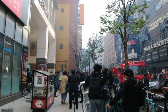 薄く煙に包まれ、人でごった返す区役所通り