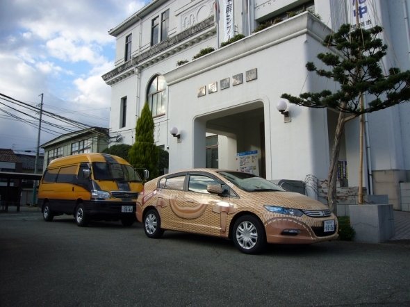 手前が柳行李かばんのラッピング公用車。奥にあるのは、廃車になった方の公用車(豊岡市が2009年に撮影)