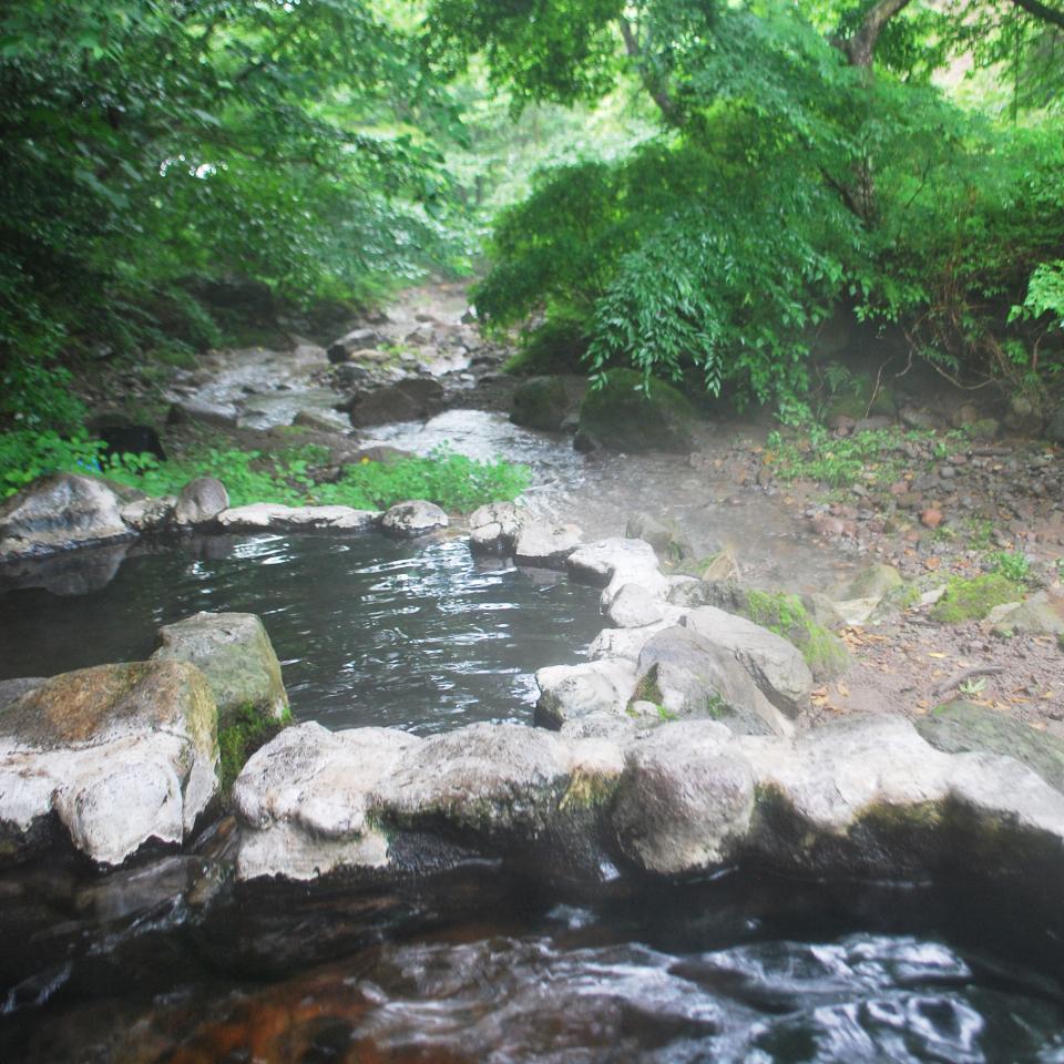 天然の川のすぐ横に野天風呂がある