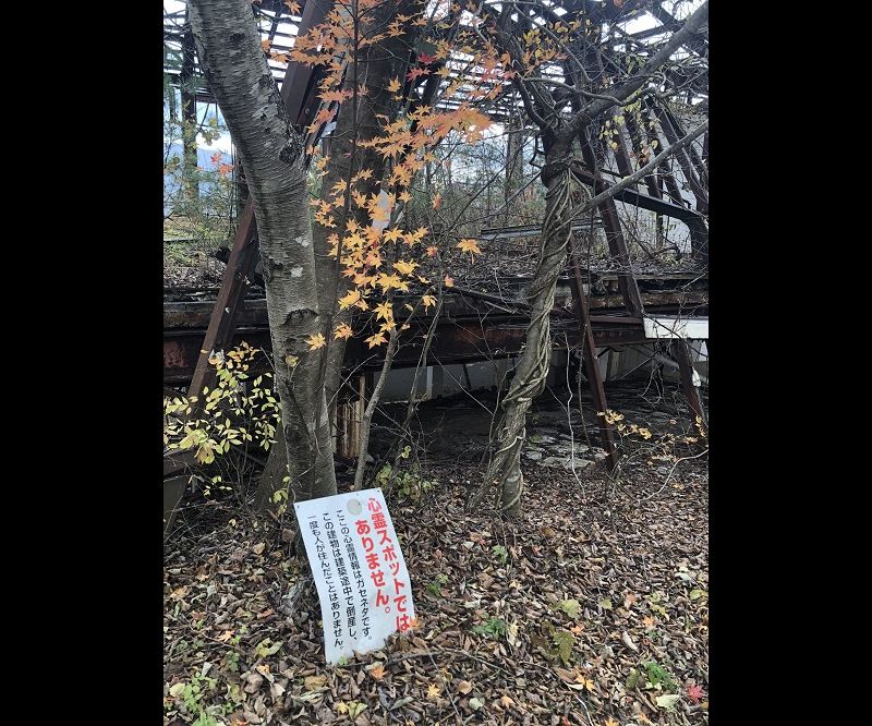 ボロボロの廃墟と紅葉......と謎の看板