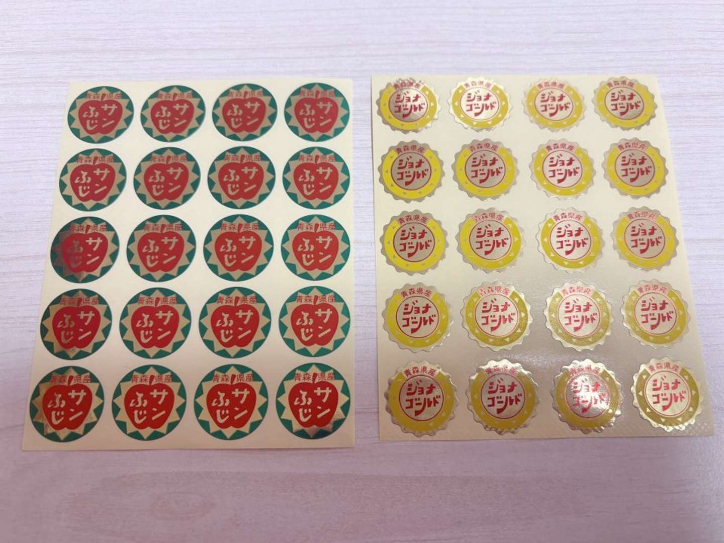 「サンふじ」と「ジョナゴールド」のシール（画像提供：弘前物産パルシー）
