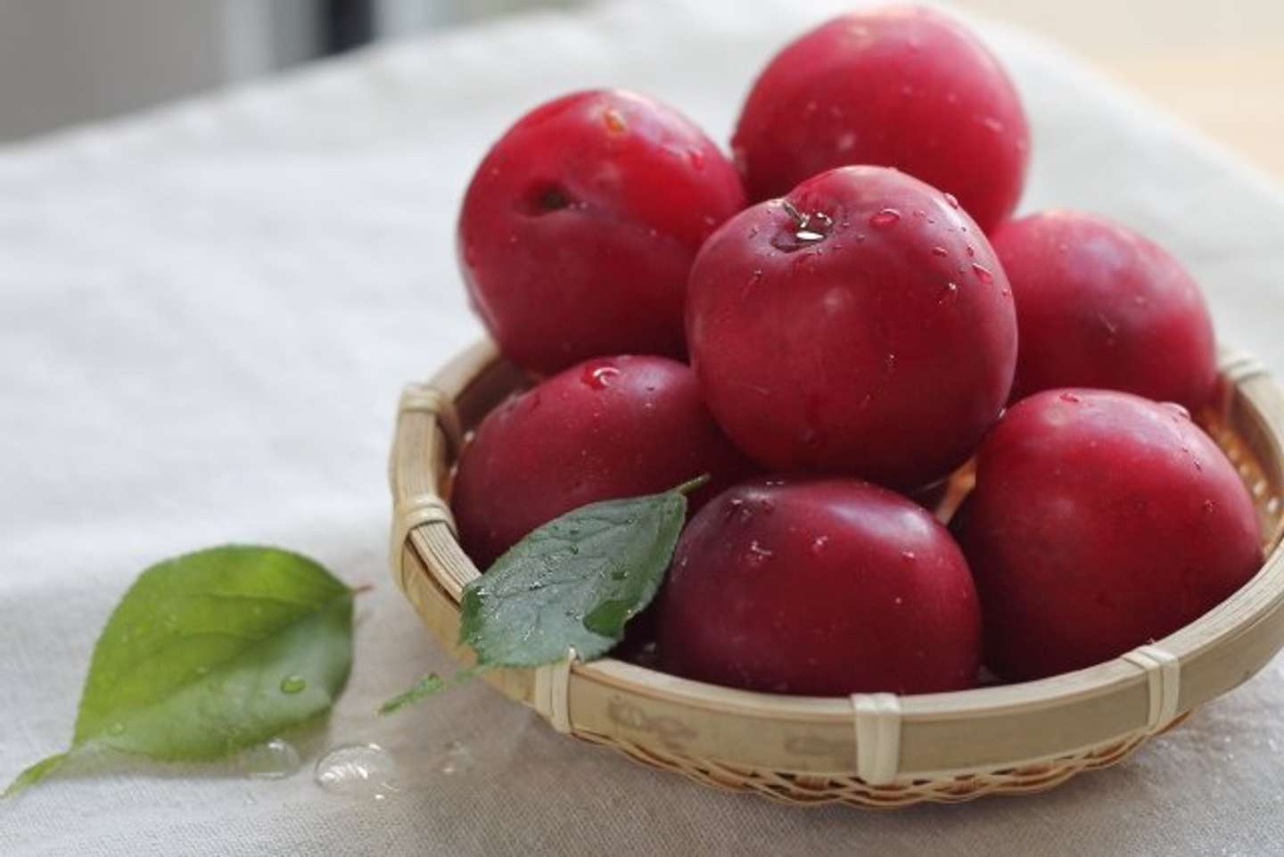 カゴいっぱいのスモモを（画像はphotoAC）